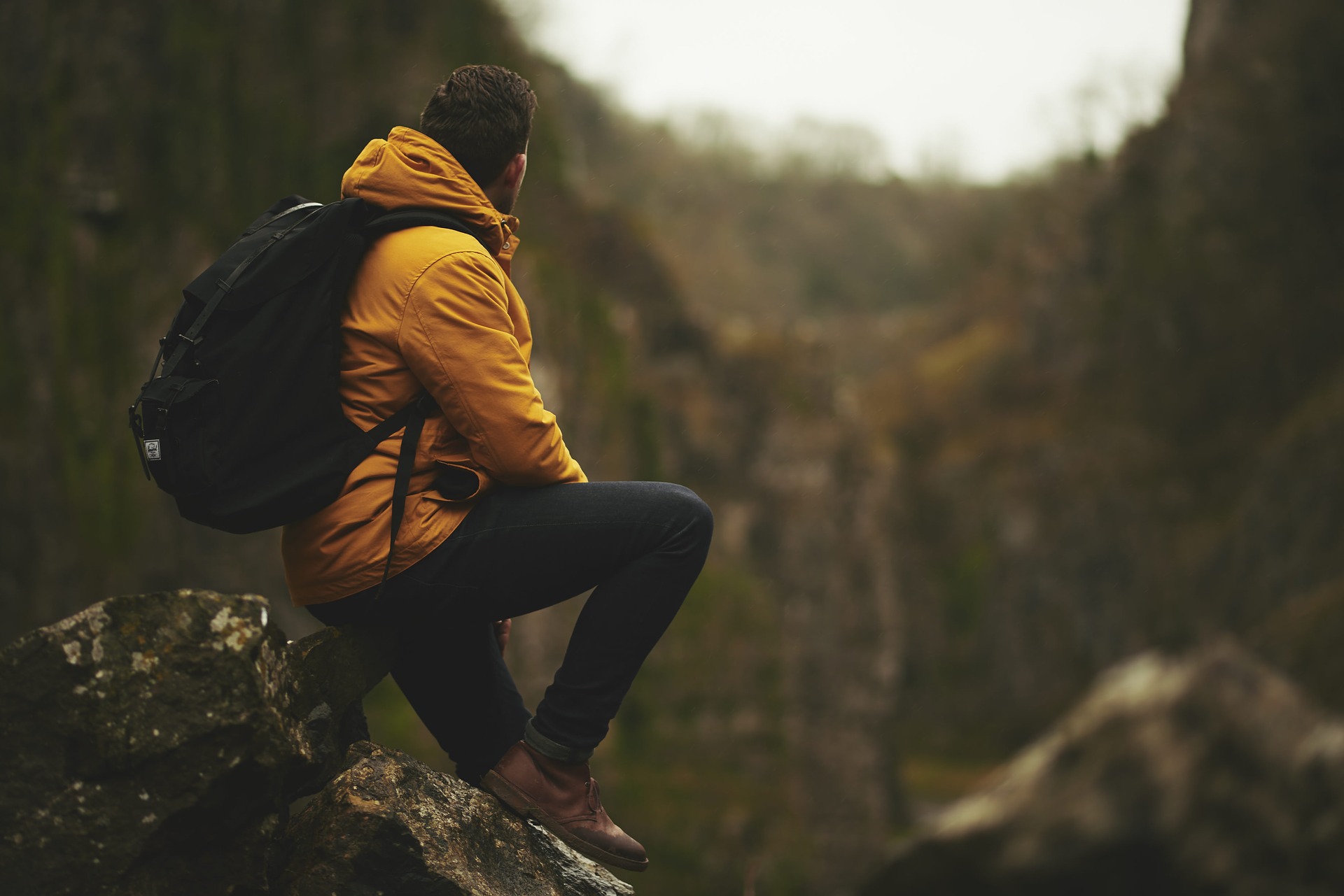 man siting on work from a hiking trip